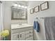Bathroom features a white vanity with a decorative mirror, towel rack, and framed coastal-themed artwork at 1808 Gray S St, Gulfport, FL 33707