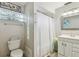 Bright bathroom featuring glass block window, a shower with curtain, vanity, and decorative wall art at 1808 Gray S St, Gulfport, FL 33707