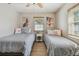 Bedroom featuring two twin beds, side table, ceiling fan and decorated with beachy artwork and nautical accents at 1808 Gray S St, Gulfport, FL 33707