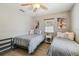 Bedroom with ceiling fan features two twin beds, side table, beachy artwork and wood laminate flooring at 1808 Gray S St, Gulfport, FL 33707
