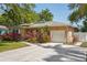Charming single-story home featuring lush landscaping, palm trees, and attached garage at 1808 Gray S St, Gulfport, FL 33707