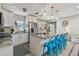 Bright kitchen features stainless steel appliances, granite countertops, an island with breakfast bar, and stylish blue bar stools at 1808 Gray S St, Gulfport, FL 33707