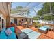 Outdoor patio featuring a screened enclosure, wood decking, furniture, and a dining table at 1808 Gray S St, Gulfport, FL 33707