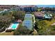 Aerial view featuring a community pool, tennis courts, lush greenery, and picturesque views of the nearby marina at 1810 Mariner Dr # 207, Tarpon Springs, FL 34689