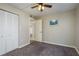 This cozy bedroom features plush carpet, a ceiling fan, and a convenient closet for ample storage at 1810 Mariner Dr # 207, Tarpon Springs, FL 34689