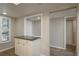 Additional kitchen counter space with cabinets, conveniently located near a doorway with bright natural light from the window at 1810 Mariner Dr # 207, Tarpon Springs, FL 34689