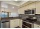 Well-equipped kitchen featuring stainless steel appliances and granite countertops, with a pass-through to living area at 1810 Mariner Dr # 207, Tarpon Springs, FL 34689
