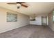 Spacious carpeted living room with a ceiling fan, complemented by an adjacent kitchen view at 1810 Mariner Dr # 207, Tarpon Springs, FL 34689