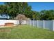 Landscaped backyard features a hot tub, mature trees, and privacy fence at 1828 Stancel Dr, Clearwater, FL 33764