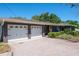 Exterior of home showcasing the spacious two-car garage and well-manicured landscaping at 1828 Stancel Dr, Clearwater, FL 33764