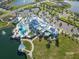 Breathtaking aerial view of the amenity center with pools, gathering spaces, tennis courts, and a large parking area at 19212 Iron Topsail Isle, Land O Lakes, FL 34638