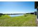 Spacious backyard with a serene lake view, lush green lawn, and well-maintained landscaping at 19212 Iron Topsail Isle, Land O Lakes, FL 34638