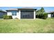 View of the backyard showcasing a well-maintained lawn and screened lanai, ideal for outdoor entertaining and relaxation at 19212 Iron Topsail Isle, Land O Lakes, FL 34638