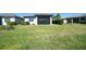 The backyard features green grass and screened in porch with outdoor ceiling fan at 19212 Iron Topsail Isle, Land O Lakes, FL 34638