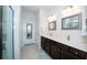 Modern bathroom with double sink vanity, framed mirrors, and a glass door shower at 19212 Iron Topsail Isle, Land O Lakes, FL 34638