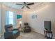 Cozy bedroom featuring string lights, two comfy chairs, a ceiling fan, and a view of the bright window at 19212 Iron Topsail Isle, Land O Lakes, FL 34638