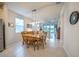 An open floorplan dining room with a wooden table and chairs beneath a modern pendant light fixture at 19212 Iron Topsail Isle, Land O Lakes, FL 34638