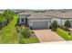 Beautiful home featuring lush green lawn, brick driveway, and neatly trimmed landscaping, with well-manicured curb appeal at 19212 Iron Topsail Isle, Land O Lakes, FL 34638