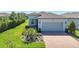 Inviting single-Gathering home showcasing a paver driveway, lush landscaping, and a two-car garage at 19212 Iron Topsail Isle, Land O Lakes, FL 34638