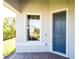 Charming home entry with a navy blue front door, decorative sidelight, and classic brick landing at 19212 Iron Topsail Isle, Land O Lakes, FL 34638