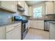 Well-lit kitchen featuring stainless steel appliances, granite countertops, and white cabinetry for a fresh, modern look at 19212 Iron Topsail Isle, Land O Lakes, FL 34638