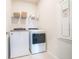 Bright laundry room with modern Whirlpool washer and dryer, storage shelf, and electrical panel at 19212 Iron Topsail Isle, Land O Lakes, FL 34638