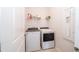 Convenient laundry room with white appliances, upper shelving, and crisp white walls at 19212 Iron Topsail Isle, Land O Lakes, FL 34638