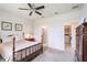 This primary bedroom features a ceiling fan, a bed, and a view into the ensuite bathroom and walk-in closet at 19212 Iron Topsail Isle, Land O Lakes, FL 34638
