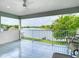 Covered balcony with tile flooring offering stunning views of the lake and lush green landscape beyond at 2327 Shirecrest Cove Way, Lutz, FL 33558