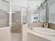 This bathroom displays a walk-in shower and soaking tub near a large window at 2327 Shirecrest Cove Way, Lutz, FL 33558