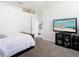 This bedroom provides a serene retreat with a TV, soft lighting, and a view into an adjacent room at 2327 Shirecrest Cove Way, Lutz, FL 33558