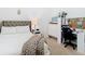 Cozy bedroom featuring a gray button-tufted headboard and a comfortable workspace with modern chair at 2327 Shirecrest Cove Way, Lutz, FL 33558