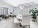 Open-concept dining room with tray ceilings, shuttered windows and elegant chandelier at 2327 Shirecrest Cove Way, Lutz, FL 33558