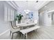 Bright dining room featuring tray ceilings, a modern chandelier, and shuttered windows for abundant natural light at 2327 Shirecrest Cove Way, Lutz, FL 33558
