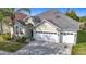 Charming home features a three-car garage, meticulously maintained lawn, and lush landscaping for enhanced curb appeal at 2327 Shirecrest Cove Way, Lutz, FL 33558