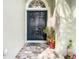 Elegant double front door with an arched transom window and decorative flower pots creates an inviting entrance at 2327 Shirecrest Cove Way, Lutz, FL 33558