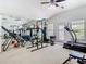 Spacious gym with mirrors, high ceilings, natural light, and equipped with a variety of exercise machines at 2327 Shirecrest Cove Way, Lutz, FL 33558