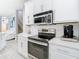 Modern kitchen with white cabinetry, stainless steel appliances, and quartz countertops at 2327 Shirecrest Cove Way, Lutz, FL 33558