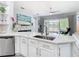 Bright kitchen with stainless steel appliances, white cabinets and a view of the backyard at 2327 Shirecrest Cove Way, Lutz, FL 33558