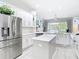 Bright kitchen with white cabinetry, stainless steel appliances, an island, and view to backyard waterfront at 2327 Shirecrest Cove Way, Lutz, FL 33558