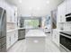 Bright kitchen featuring white cabinets, stainless steel appliances, and a large island at 2327 Shirecrest Cove Way, Lutz, FL 33558