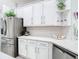 Well-lit kitchen with white cabinets, subway tile backsplash, stainless steel appliances and modern countertops at 2327 Shirecrest Cove Way, Lutz, FL 33558