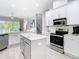 Bright kitchen with white cabinetry, stainless steel appliances, an island, and view to backyard waterfront at 2327 Shirecrest Cove Way, Lutz, FL 33558