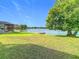 Expansive backyard with lush green grass leading to a serene lake with a dock, ideal for outdoor enjoyment at 2327 Shirecrest Cove Way, Lutz, FL 33558