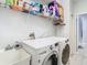 Practical laundry area with side-by-side washer and dryer, sink, and overhead storage for cleaning supplies at 2327 Shirecrest Cove Way, Lutz, FL 33558