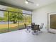 Screened in patio showcases a glass table with four chairs with a view of the lake and trees outside at 2327 Shirecrest Cove Way, Lutz, FL 33558