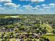 Wide aerial perspective of a residential area near a lake with tree-lined streets and attractive homes at 2329 Towering Oaks Cir, Seffner, FL 33584