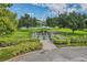 Aerial view of community dog park with green grass, benches, and shade trees at 2340 Grecian Way # 56, Clearwater, FL 33763