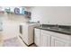 Functional laundry room with modern washer and dryer, sink, and counter space at 2979 Estancia Pl, Clearwater, FL 33761