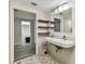 Well lit bathroom with unique honeycomb tile flooring, double sinks, wooden shelves, and large wall mirror cabinet at 36750 Us 19 N # 08102, Palm Harbor, FL 34684